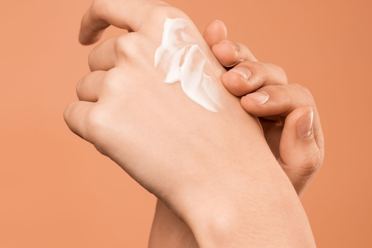 Hände mit Creme in Nahaufnahme